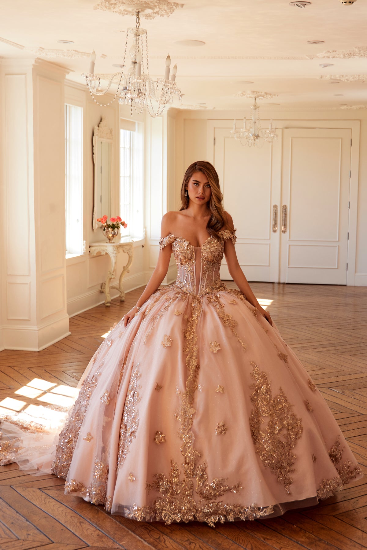 Off-shoulder corset bodice adorned with ornate embroidery and shimmering appliqués.
