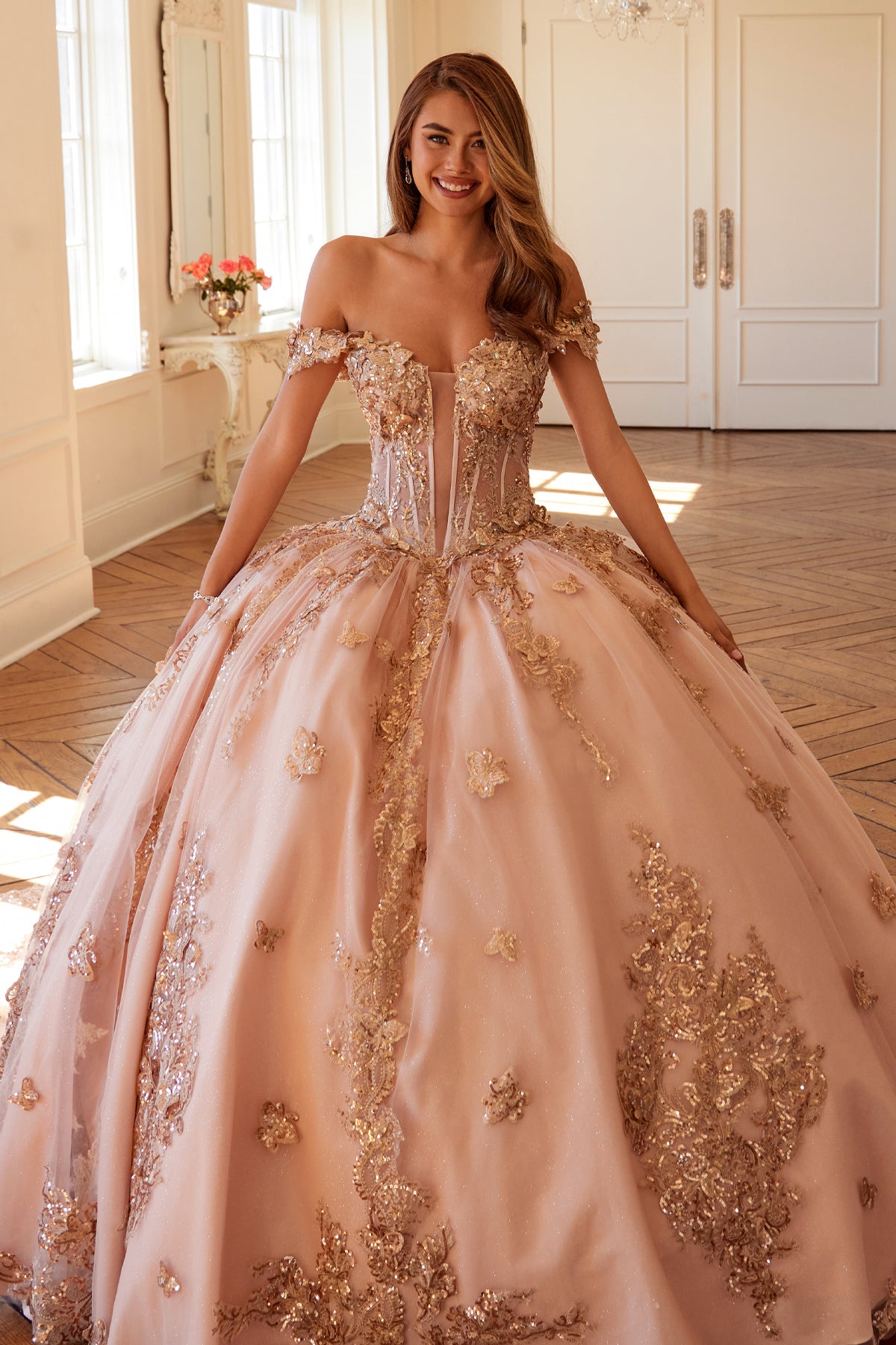 Off-shoulder corset bodice adorned with ornate embroidery and shimmering appliqués.